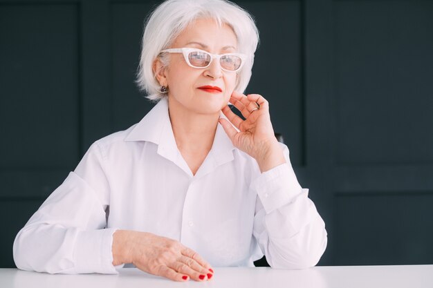 Thoughtful elderly lady portrait. Woman independence and wealthy seniority.