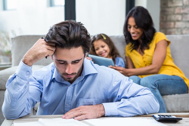 Thoughtful father paying bills in living room