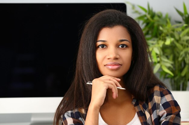 Thoughtful focused beautiful afro woman with pen