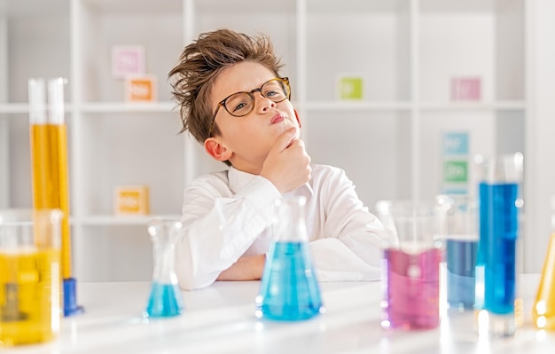 Thoughtful little scientist in chemistry lab