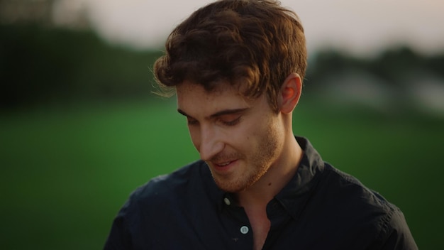 Thoughtful man feeling shy outdoors Thinking guy posing on meadow