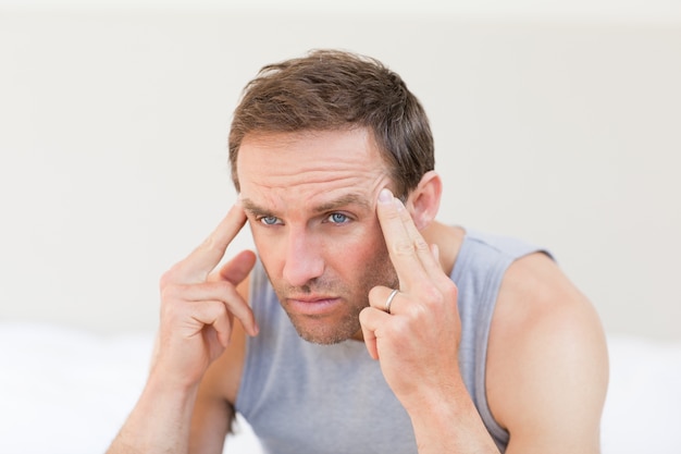 Thoughtful man sitting on his bed