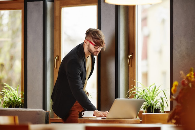 Thoughtful man standing at notebook