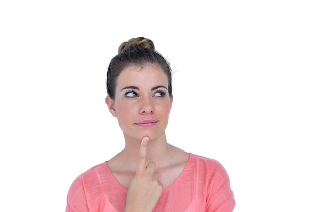 Thoughtful pretty casual brunette standing with finger on chin 