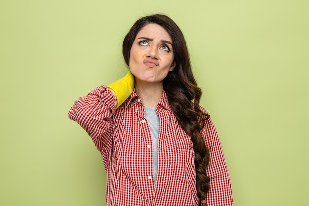 Thoughtful pretty caucasian cleaner woman with rubber gloves looking up 