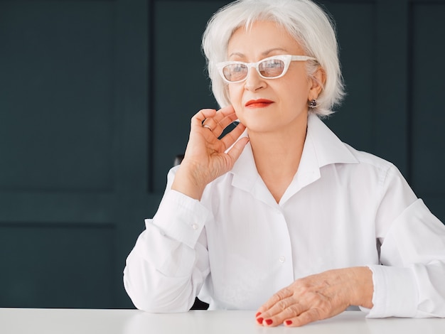 Thoughtful senior business lady portrait. Modern seniority independence