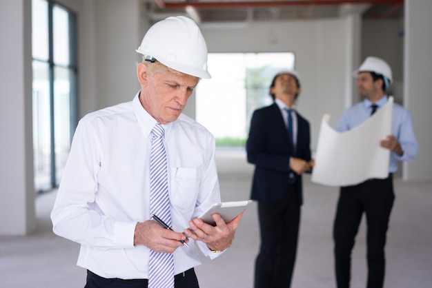 Thoughtful senior engineer working at construction site. 