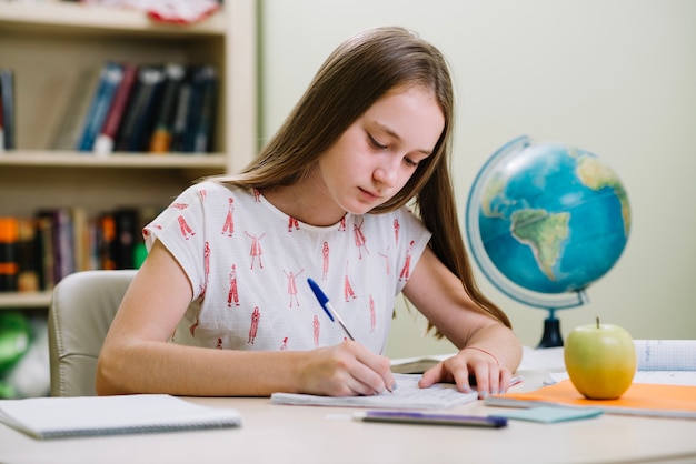 Thoughtful student girl writing