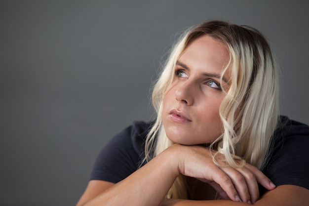 Thoughtful transgender leaning on chair