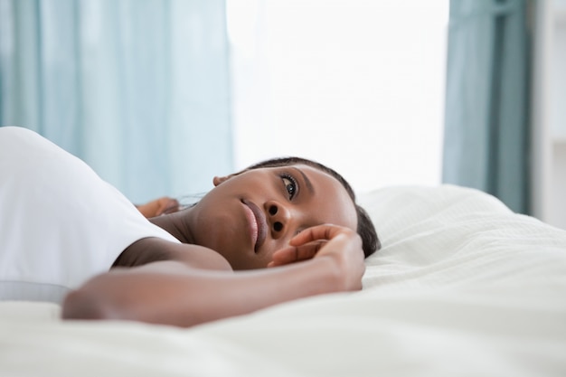 Thoughtful woman lying on her back