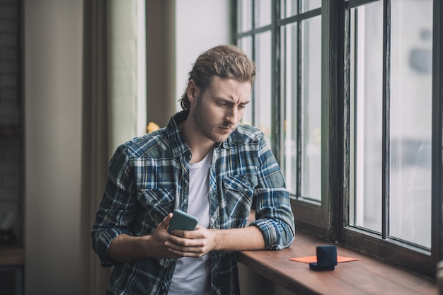 Thoughtful young man looking at the wedding ring box