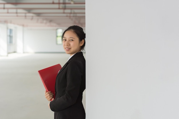 Thoughtful young pretty woman holding file and pencil Business lady thinking touching face with pencil and looking away Planning concept Isolated front view on white background