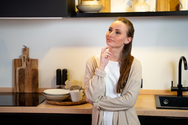 Photo thoughtful young woman in the kitchen at home