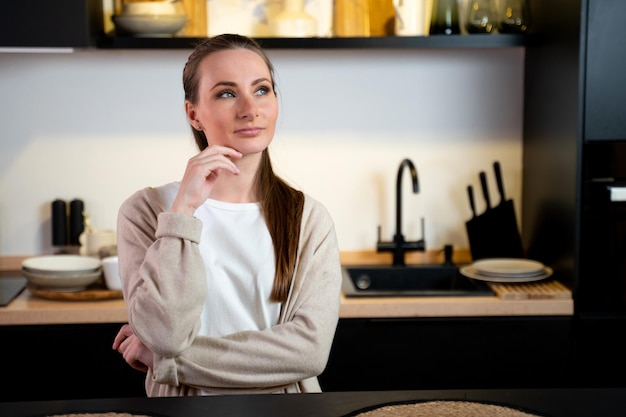 Photo thoughtful young woman in the kitchen at home