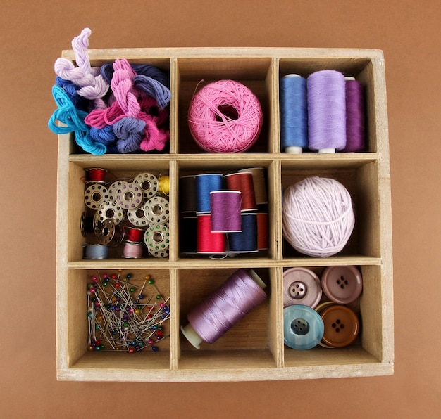 Thread and materials for handiwork in box on brown background