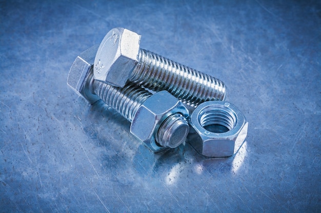 Threaded bolt details with screwnuts on metallic background construction concept