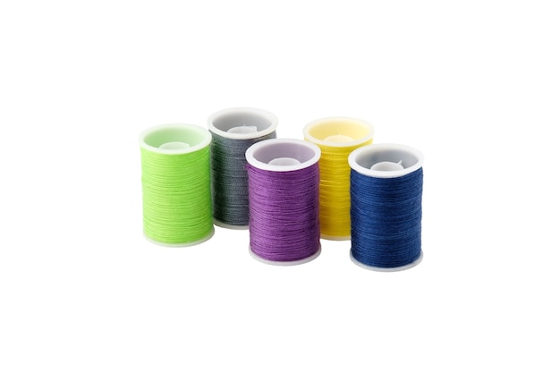 Threads of different colors on four plastic spools stand upright and isolated on a clean white background.