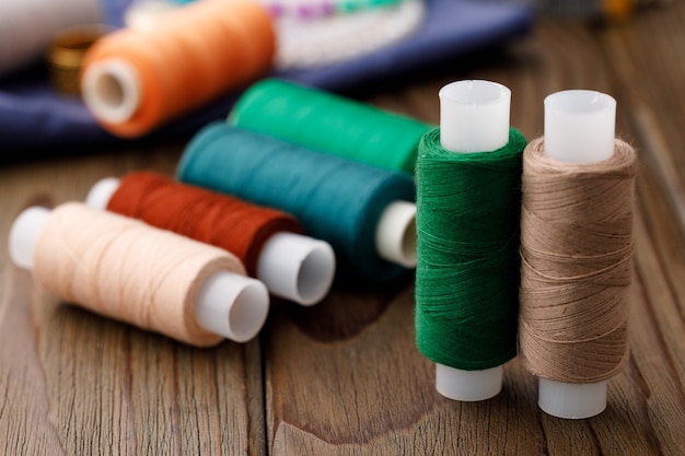 Threads and sewing accessories on brown wooden table