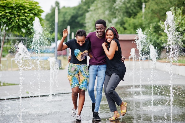 Three african american friends walking on fountains Having fun together