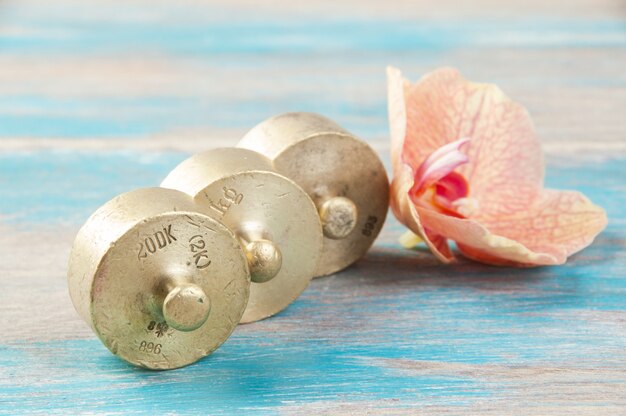 Three antique bronze weights for scales on blue wooden background. Copy space for text and food photography props.