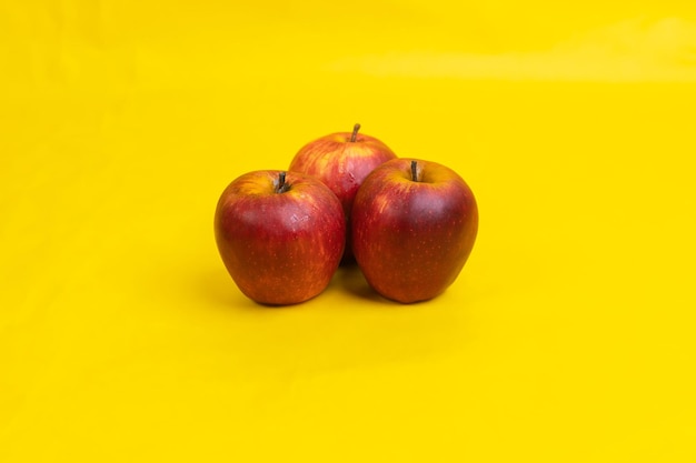 three apple on yellow background