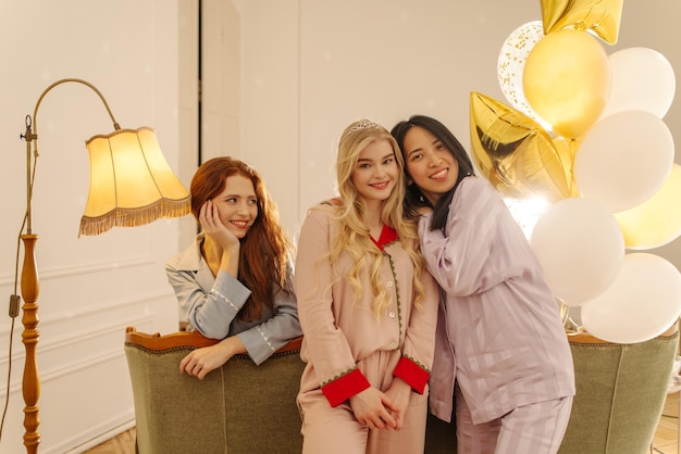 Three attractive young interracial ladies in pajamas spend time together at slumber party Lifestyle and positive attitude concept