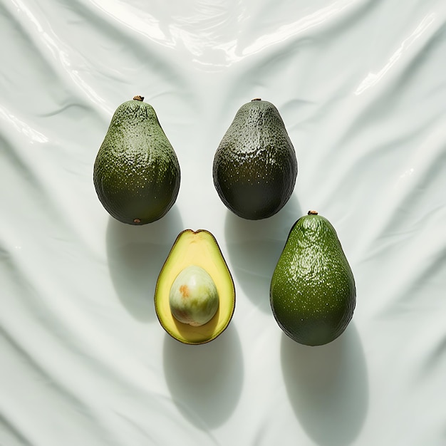 Photo three avocados are shown with their faces drawn on a white cloth