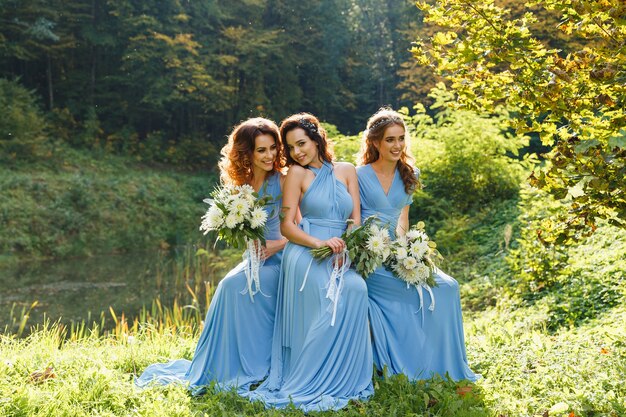 Three beautiful bridesmaids in the park on wedding day