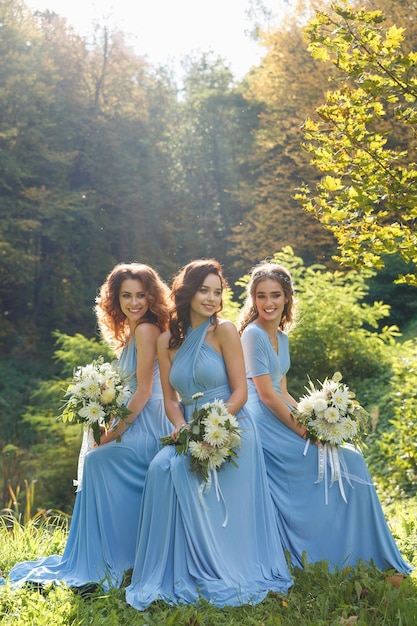 Three beautiful bridesmaids in the park on wedding day