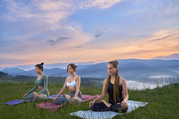 Three beautiful women in lotus pose