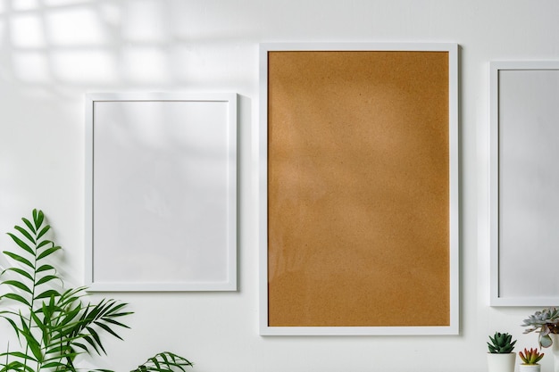 Three blank frames with copy space hanging on white wall