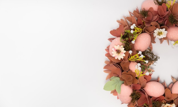 Three blue spotted chicken eggs and a wreath of willow twigs on a white background top view