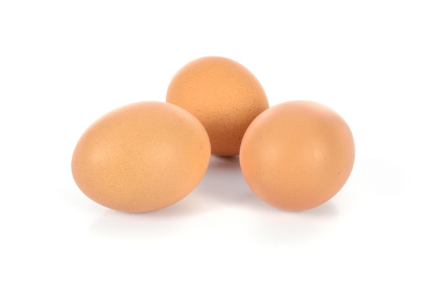 Three brown eggs in closeup and isolated on a white background