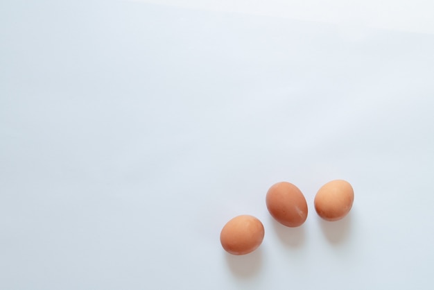 Three brown eggs on a white background