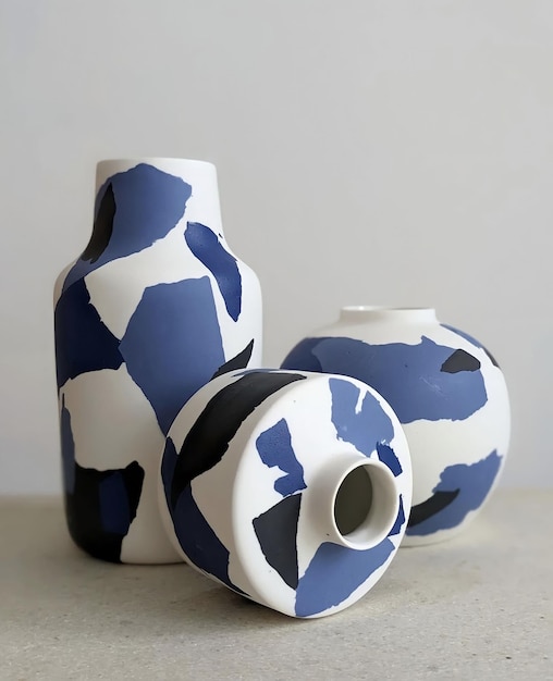 Photo three ceramic vases with blue and white designs are sitting on a table.