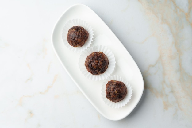 Three chocolate candies sweets on white plate