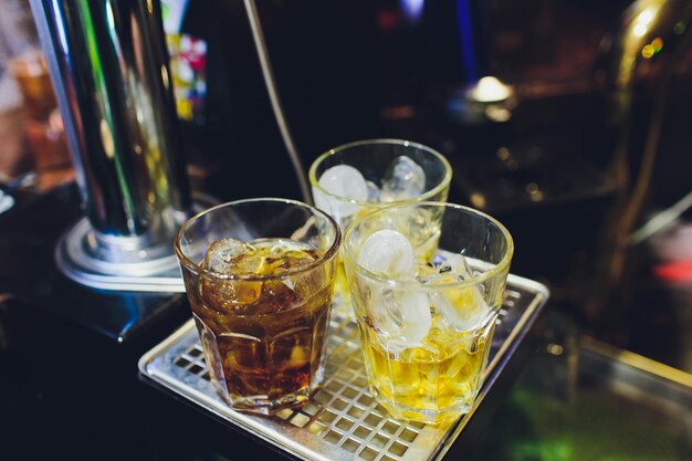 Three cocktails on the bar Whiskey Cola Rum Cola Whiskey with juice on the bar during a nightclub party