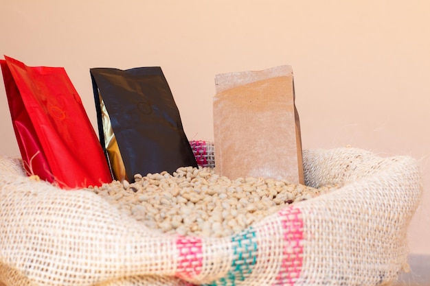 Three coffee packaging bags. Paper bags for coffee on sack full of coffee beans.