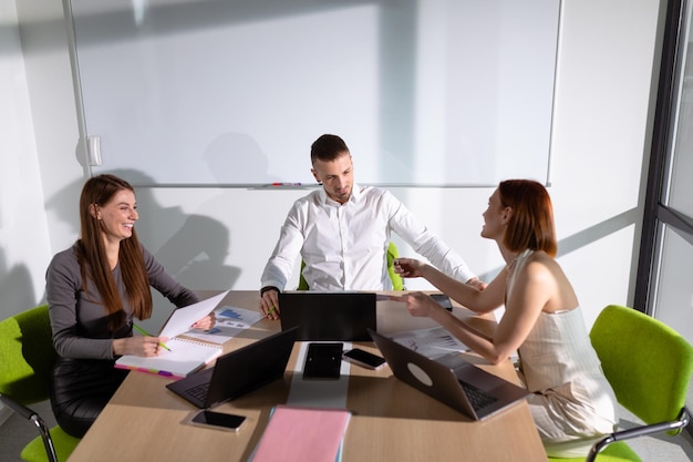 Three colleagues are in the meeting room discussing business projects Selective focus in the center of the photo