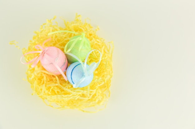 Three colored eggs lie in the nest on a white background with copyspace view from the side of Von Easter