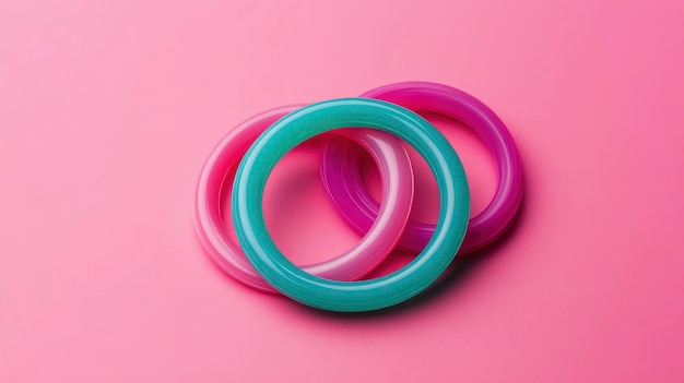 Photo three colorful rings intertwined on pink background