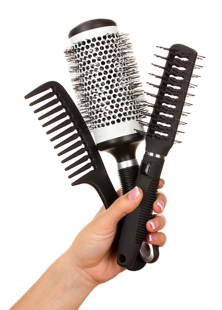 Three combs in female hand isolated on white