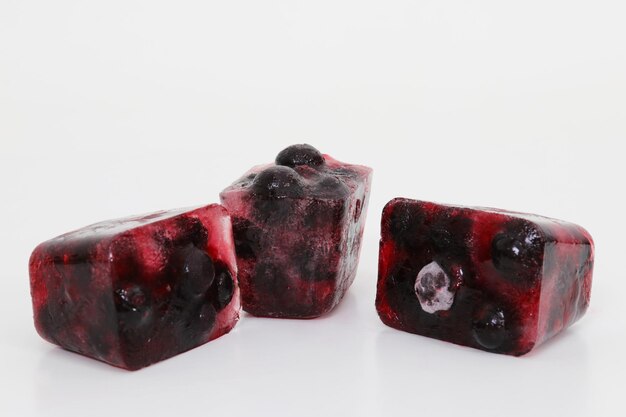 Three cubes of blueberry ice cubes on a white background