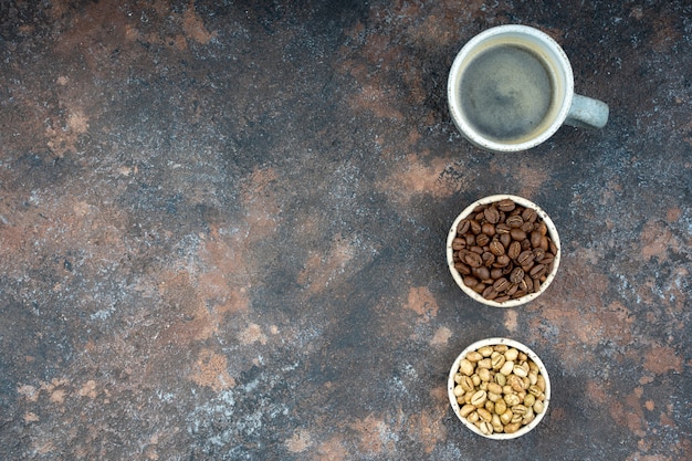 Three cups with different stages of coffee. Green and roasted beans, americano.