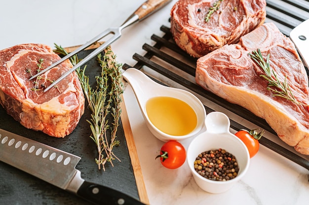 Three delicious steaks ready to grill on a white marble surface