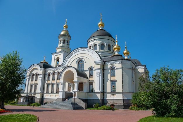 Three domes with crosses one golden and two green of the Orthodox Church blue sky