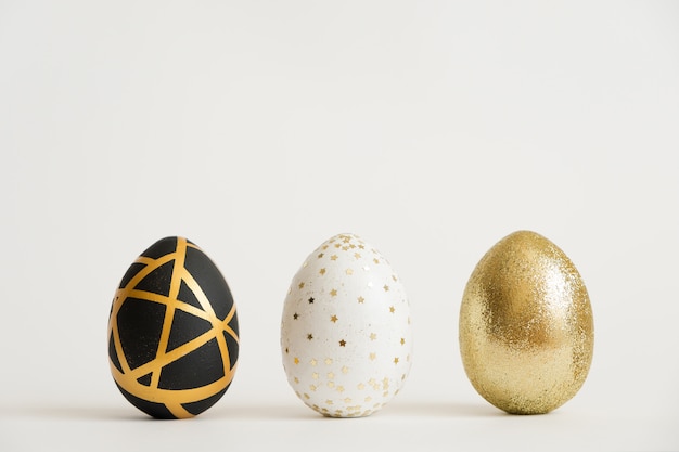 Three Easter golden decorated eggs. Minimal easter concept