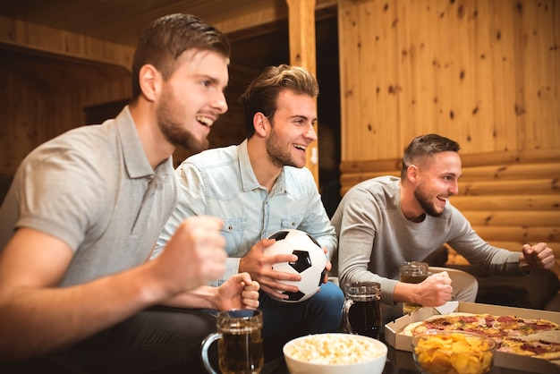 The three emotion men watch a football and gesture