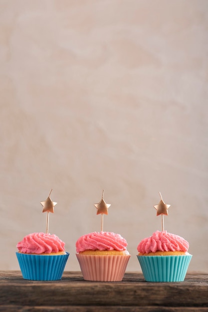 Photo three festive cupcakes decorated with cream and candles. birthday cupcake. party muffin. copy space.