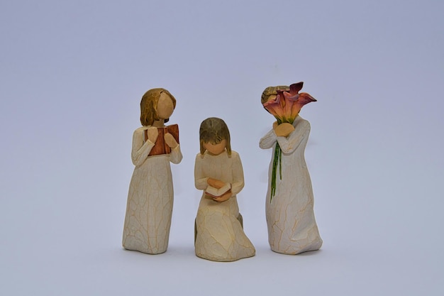 three figurines of three different sizes one of which has a flower in it